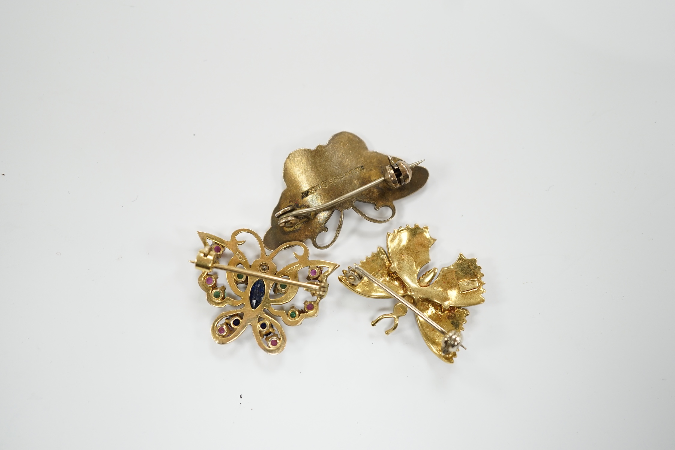 Three assorted butterfly brooches, sterling and enamel, 18k and enamel and 9ct gold and gem set, width 25mm.